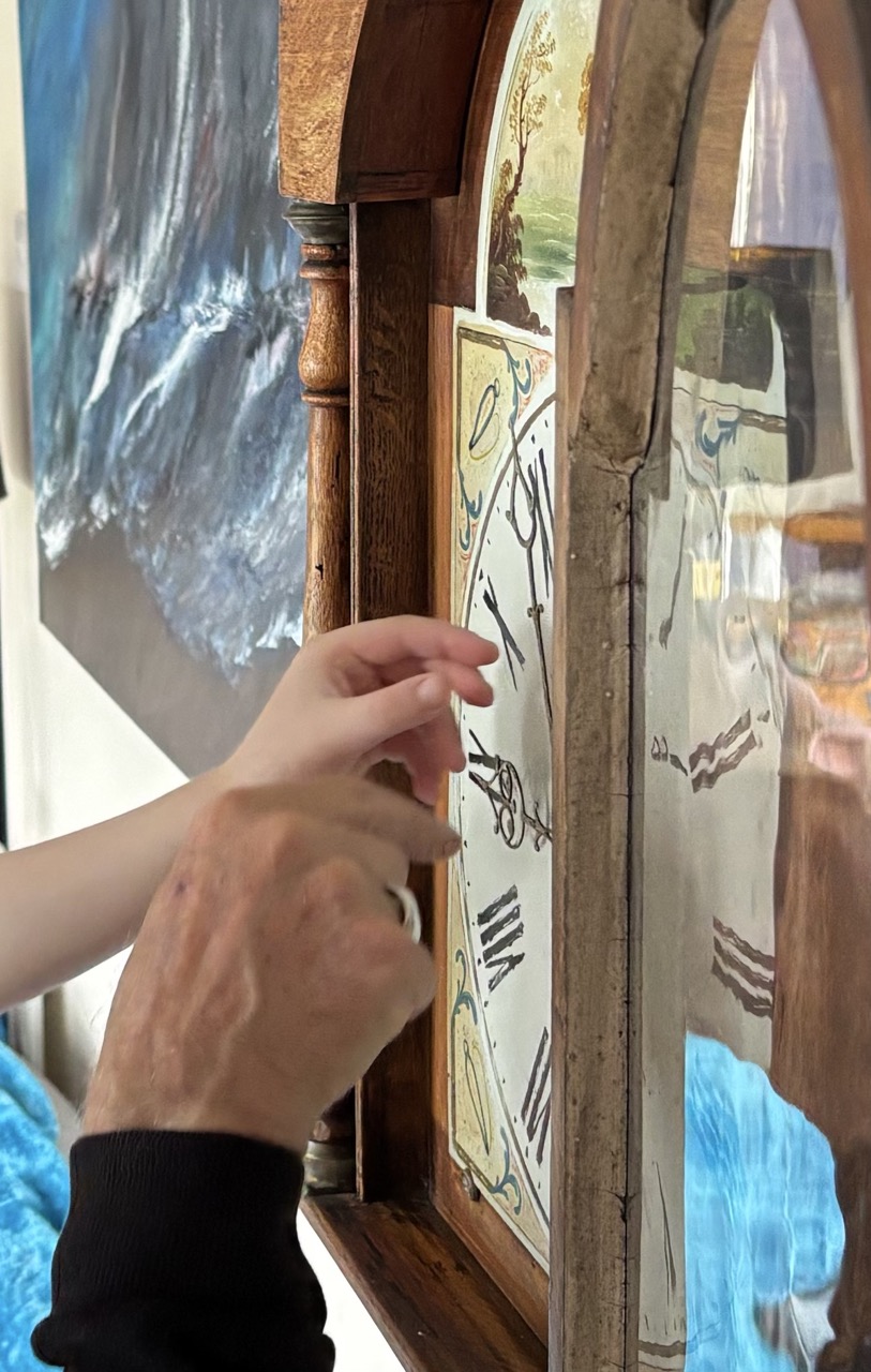 Hands setting a grandmother clock